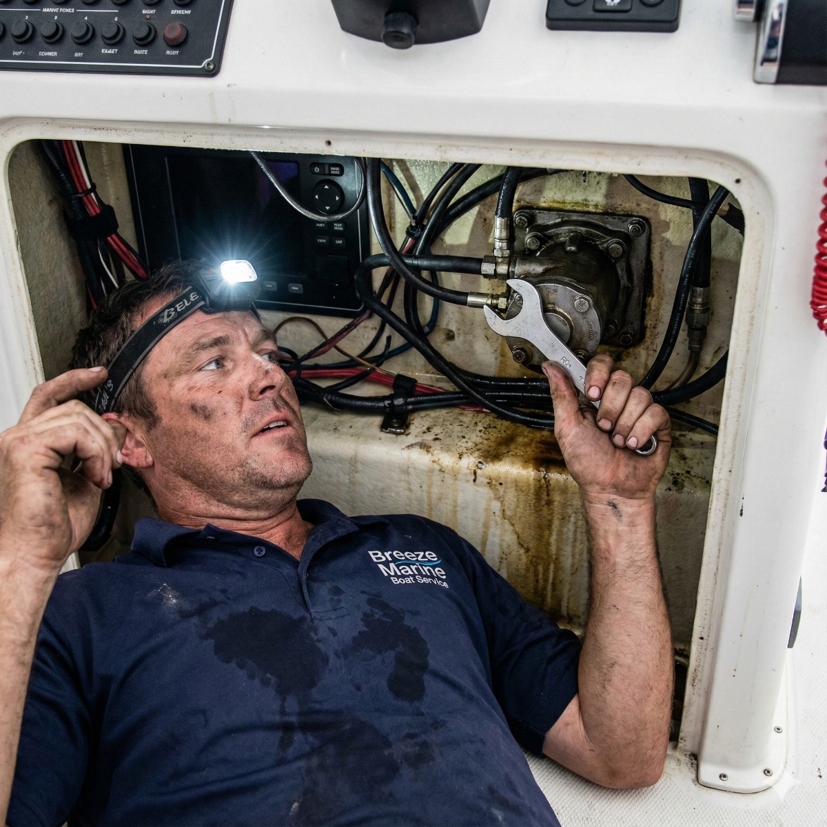 Marine technician working under a boat console